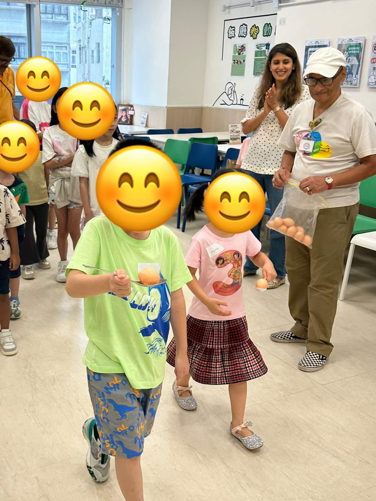 Two children walk through the room during a group game.