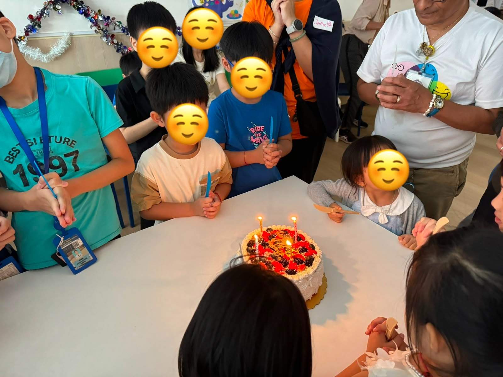 Children gather around the cake before the candles are blown out.