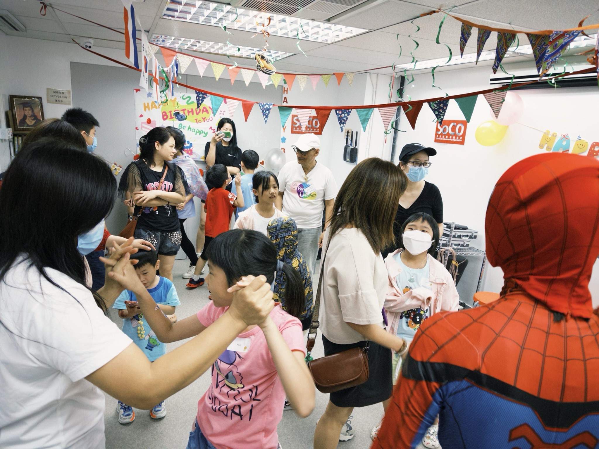 Adults and children gather closely around the costumed performer.