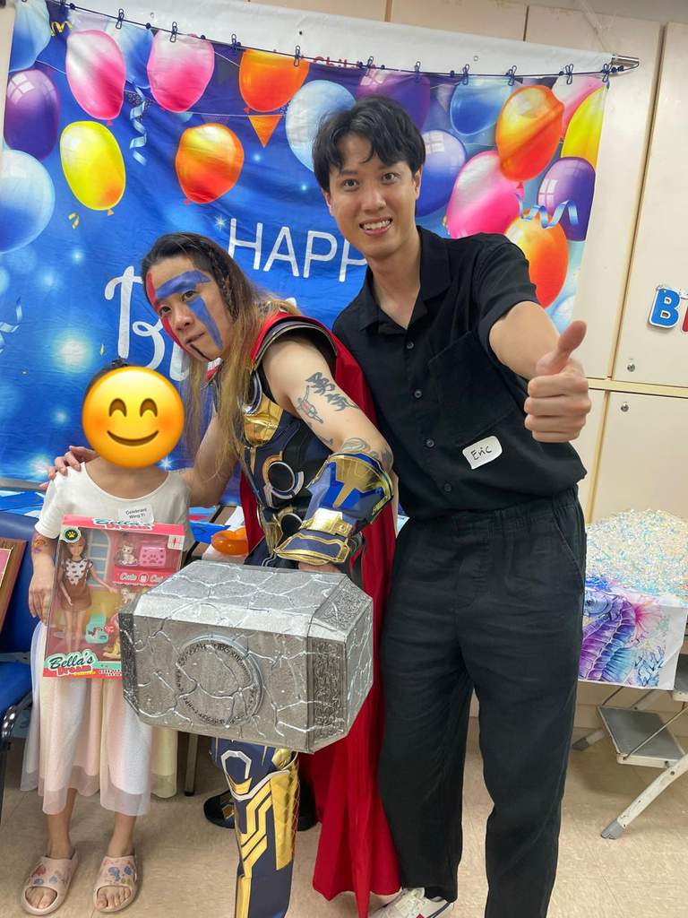A costumed performer and adult pose with a child holding boxes.