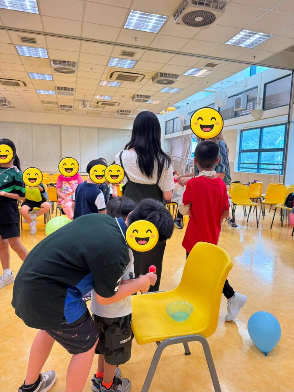 A participant carries a small object around a yellow chair.
