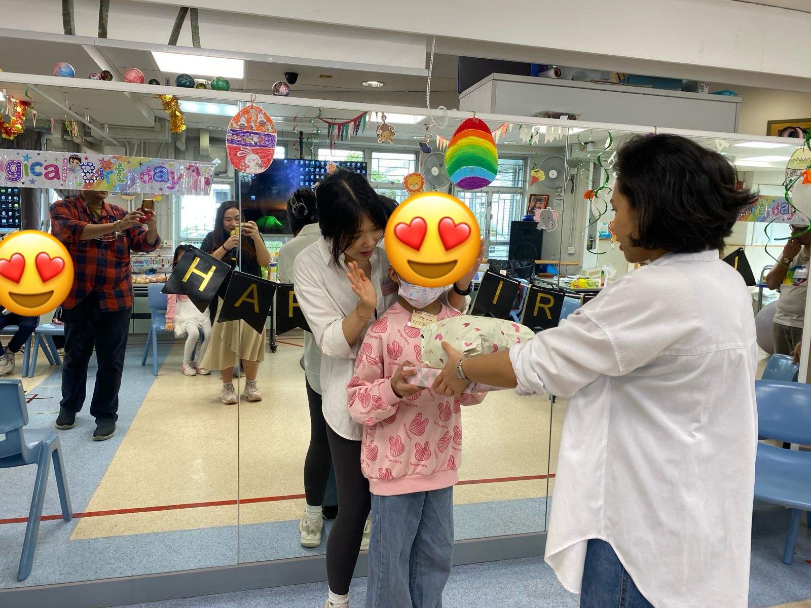 An adult presents a wrapped gift to a participant.