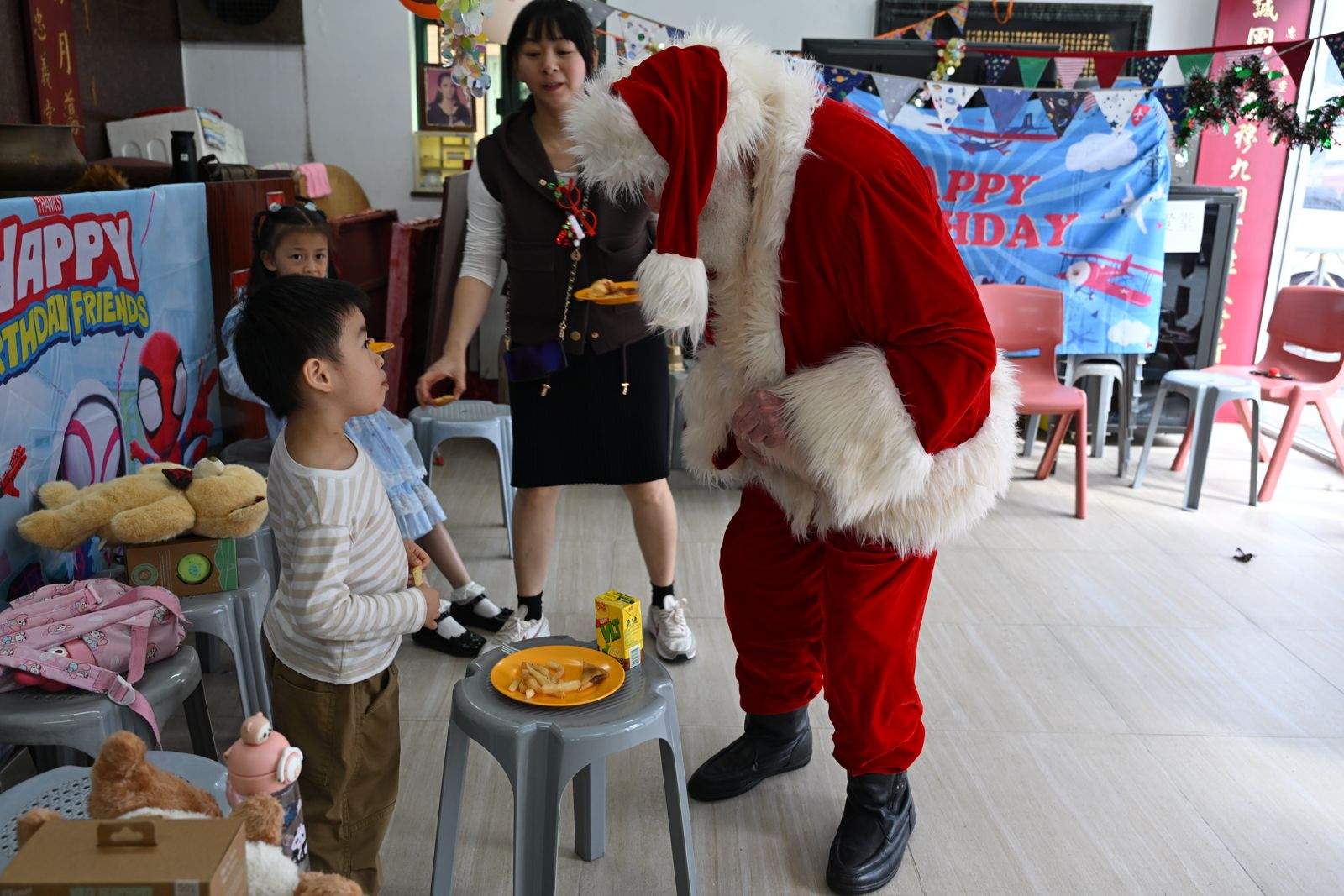 A child stands facing a seated costumed adult.