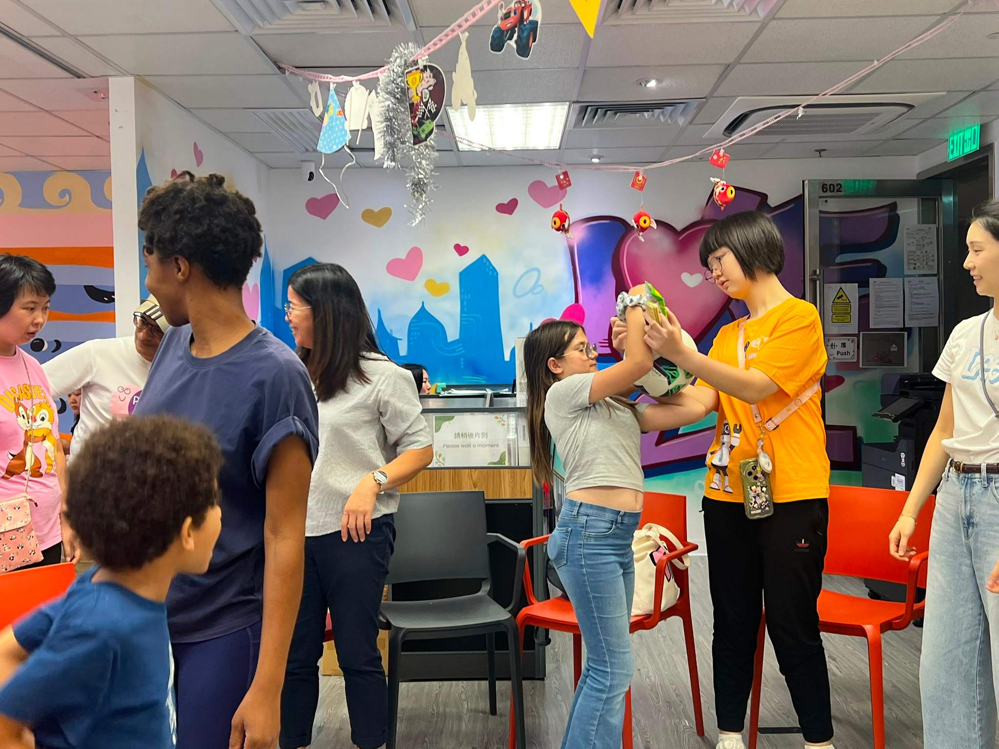 Two adults raise their hands during a group activity.