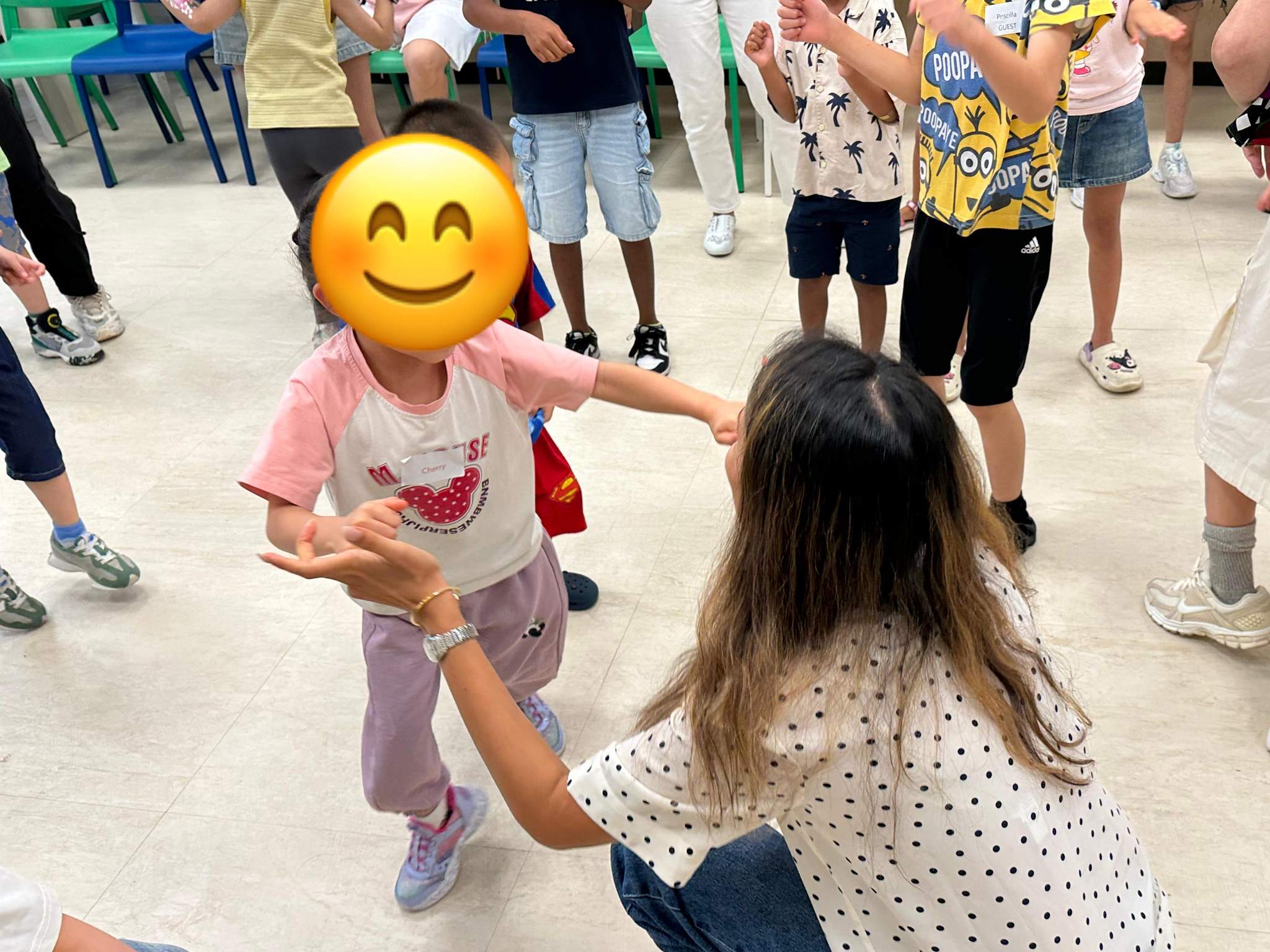 Two children face each other during a circle game.