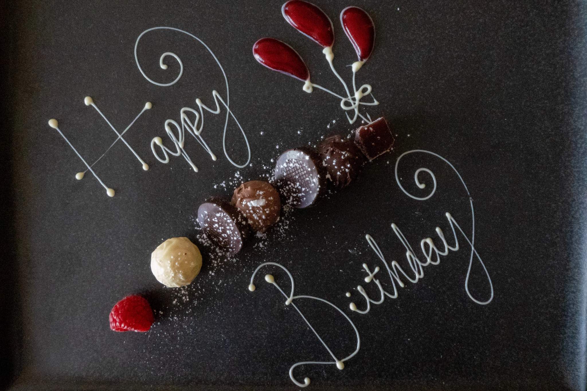Chocolate truffles and strawberry slices form a decorative tabletop arrangement.