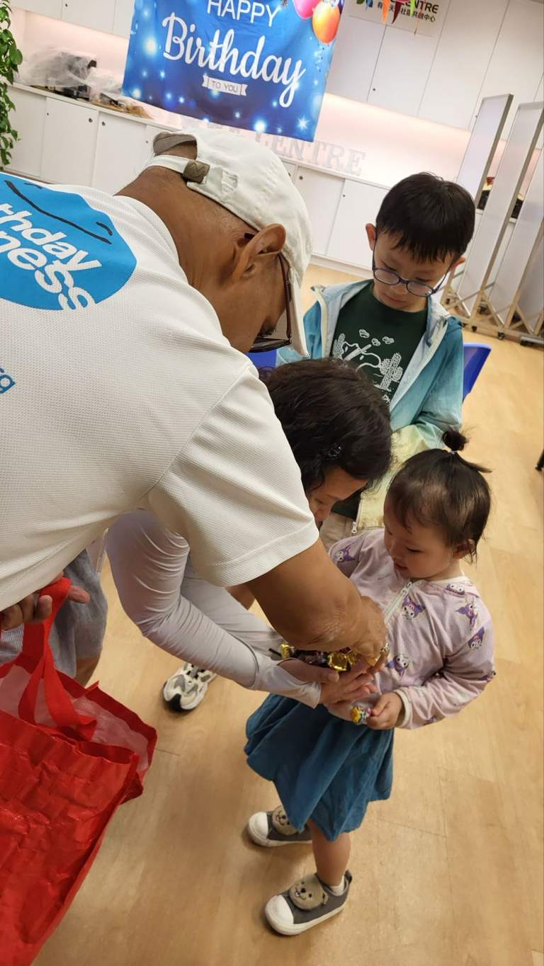 Adults help a child choose an item from a bag.