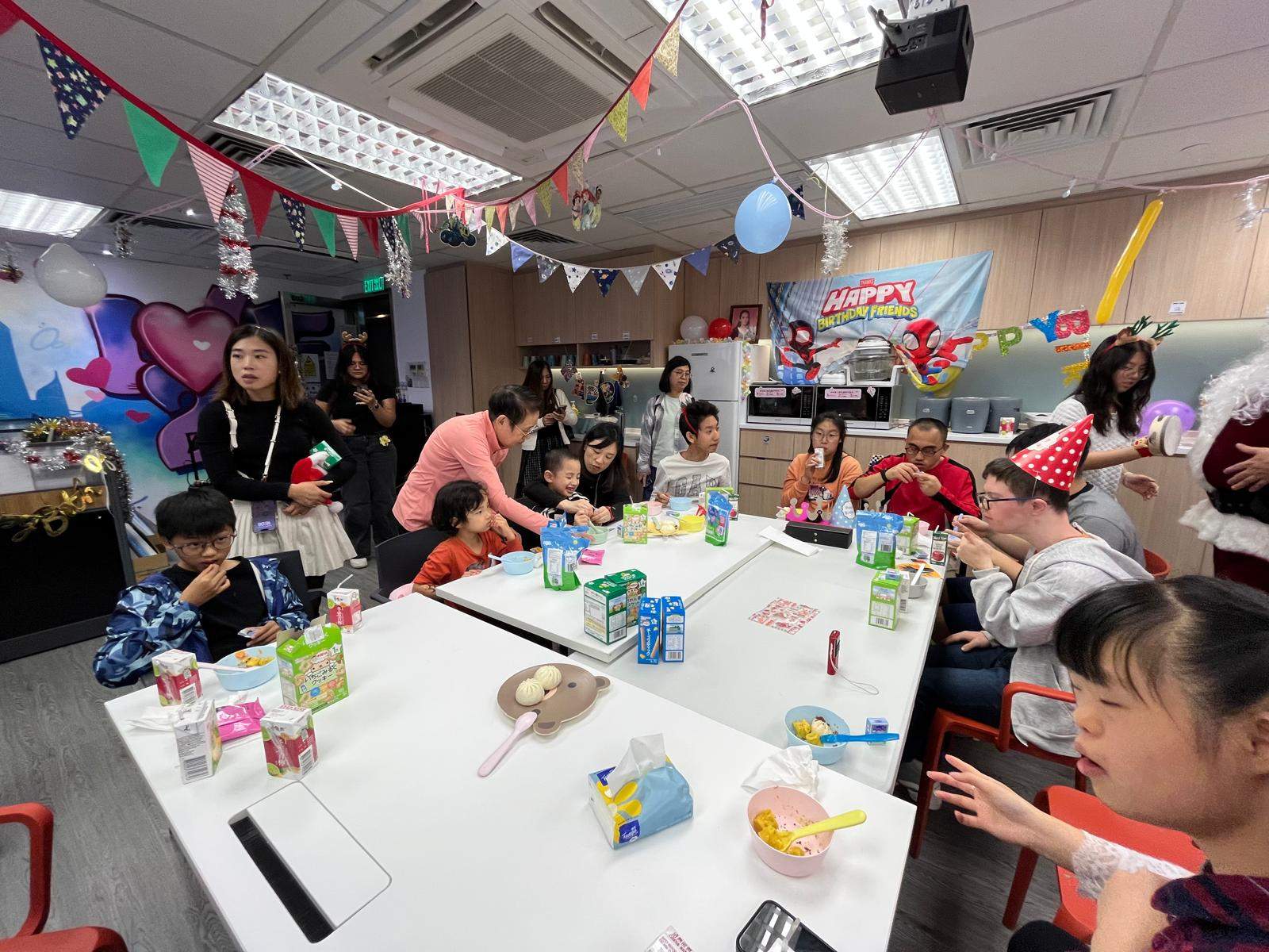 People sit around a long table beneath festive decorations.