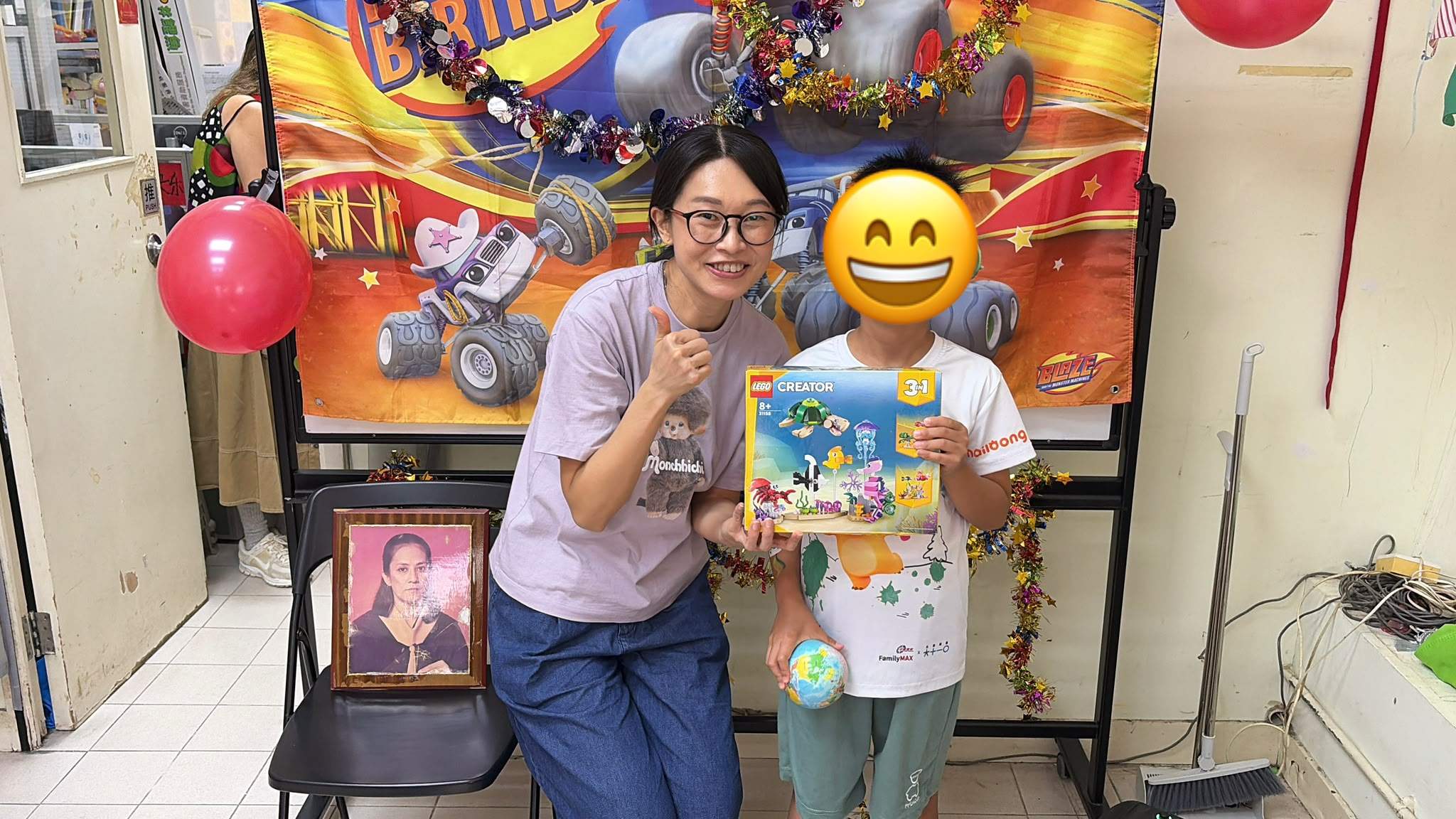 A volunteer poses with a child holding a building-set gift.