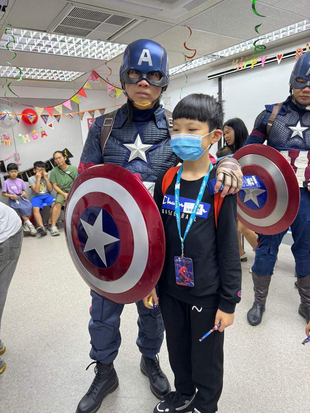 Costumed performers pose with a child holding round shields.