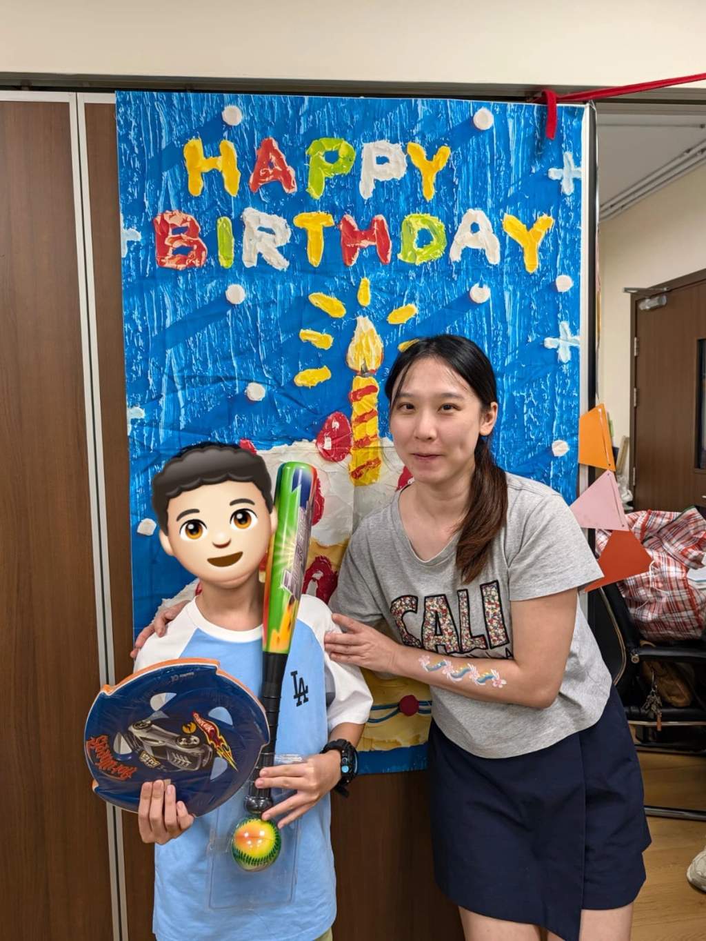 A child holds party gifts while posing with a volunteer.