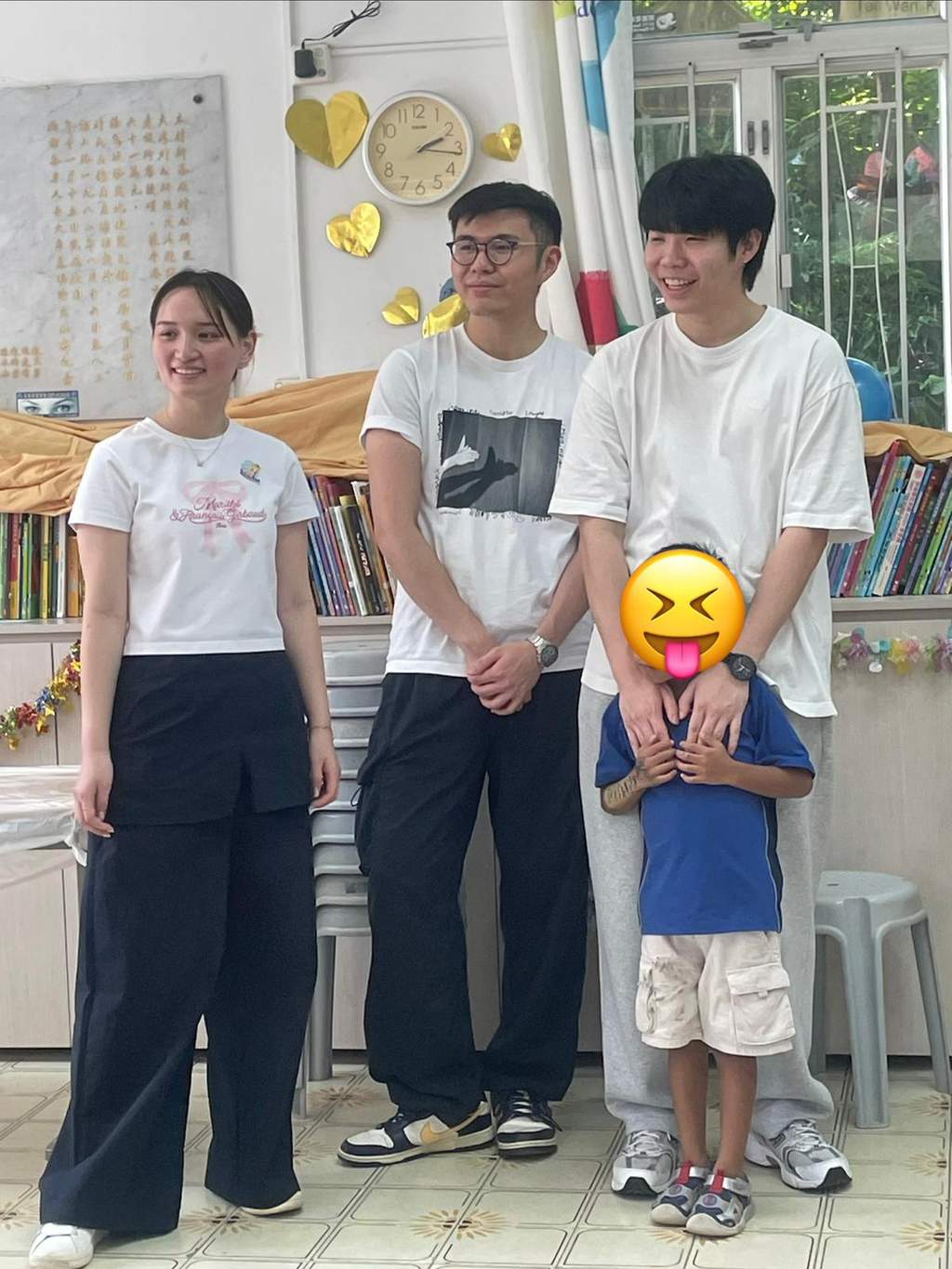 Three adults and a child pose together indoors.