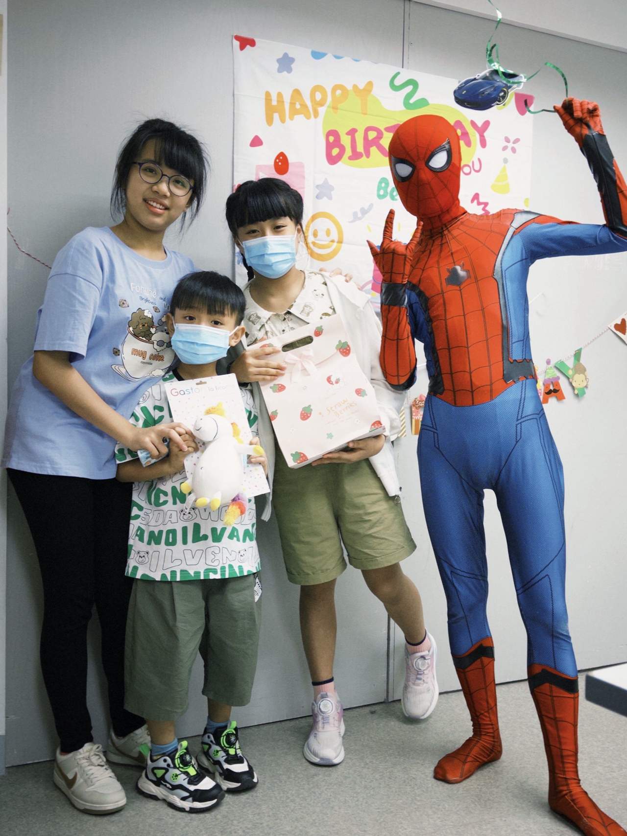 Two adults, two children, and a costumed performer pose together.