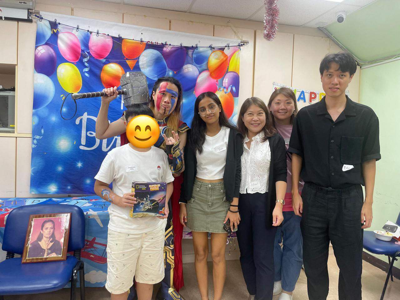 A child holding a gift poses with four adults.