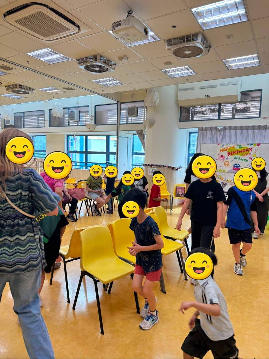Participants move around yellow chairs during a group game.