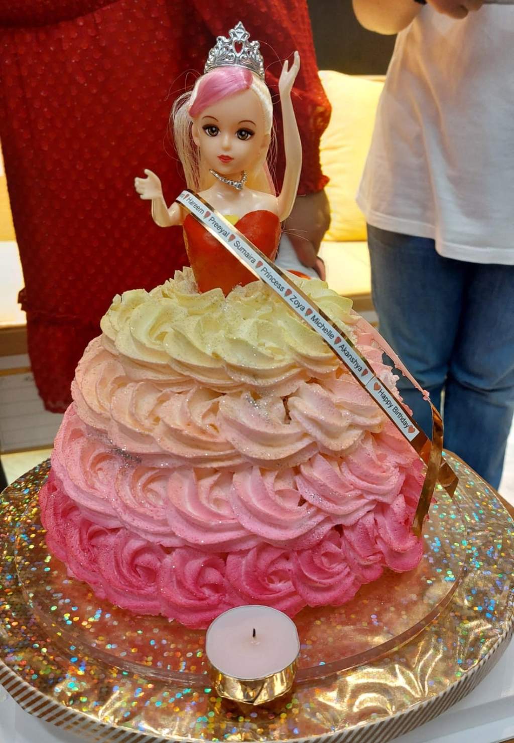 A pink ombre doll cake with a Happy Birthday sash naming each celebrant, by Bharti.