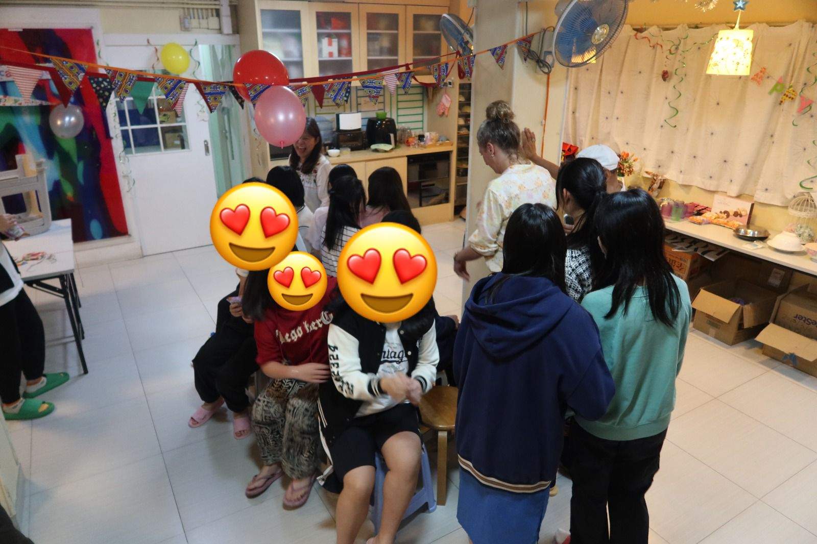 People gather around seated participants near the food table.
