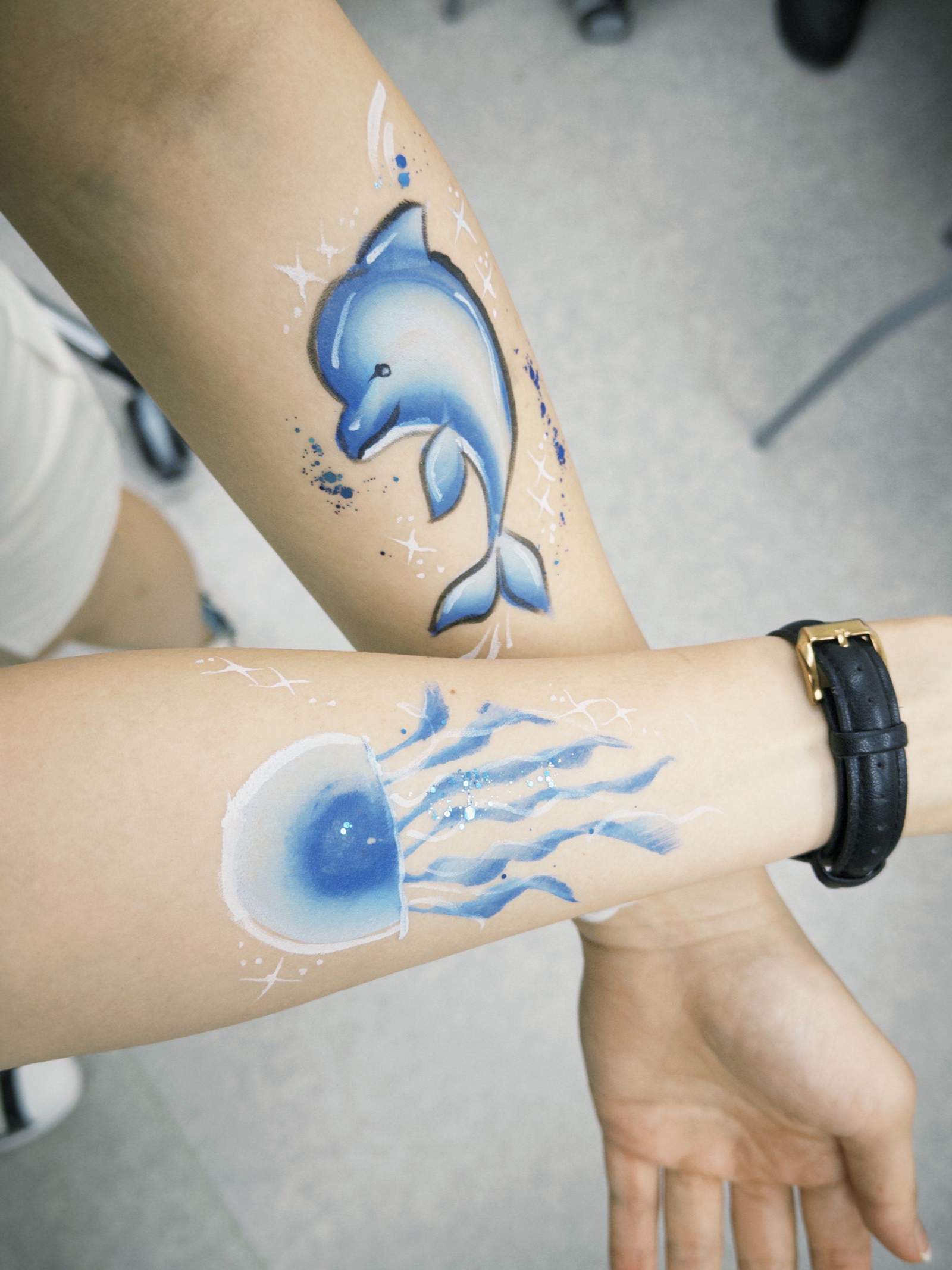 Painted sea creatures are displayed across two forearms.