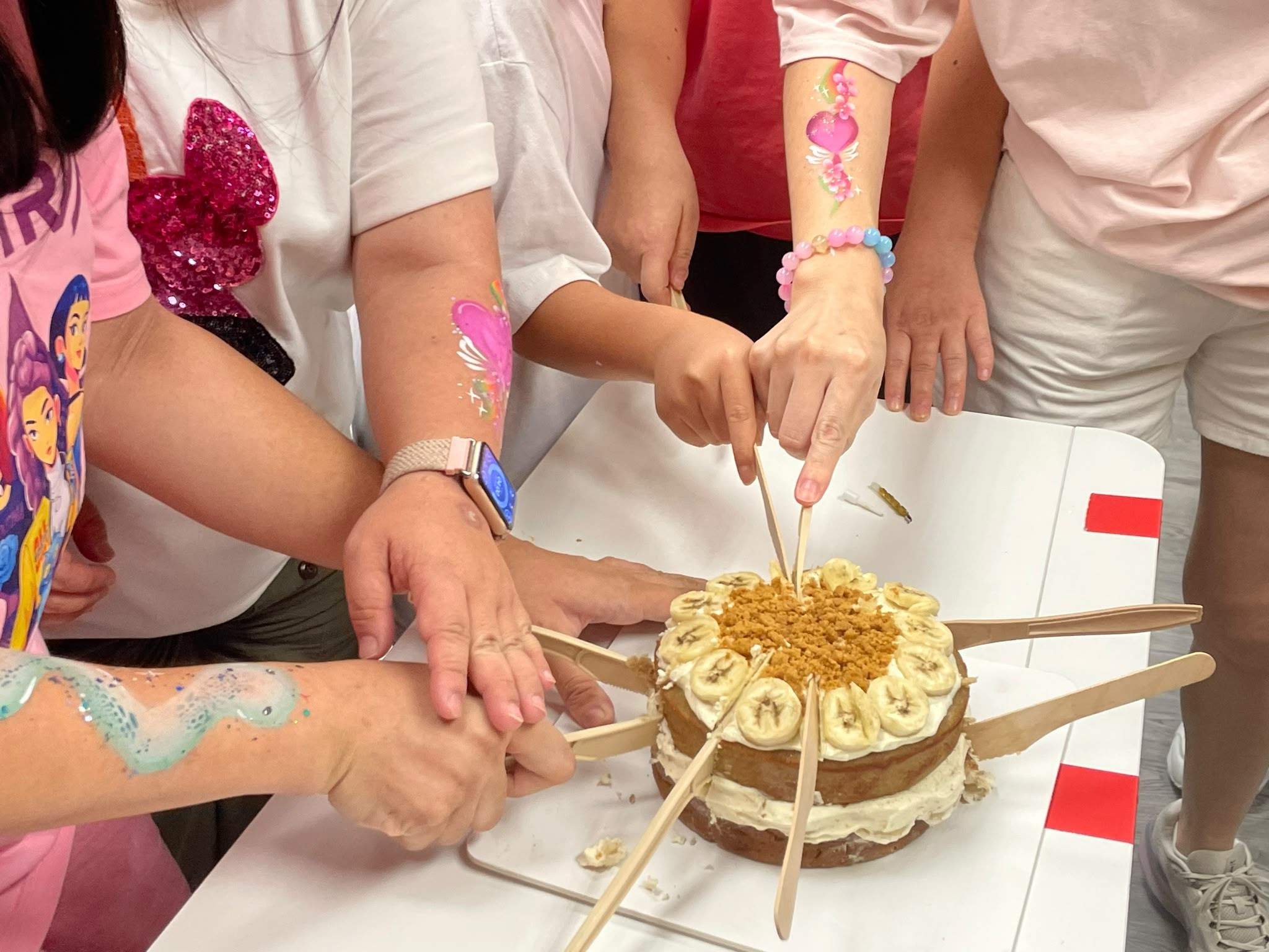 Several participants cut the decorated birthday cake together.
