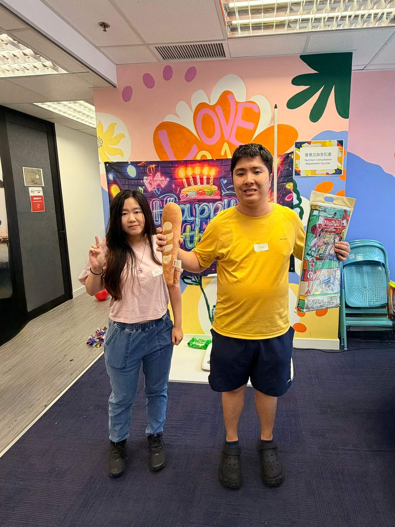 Two people pose together while holding several small gifts.