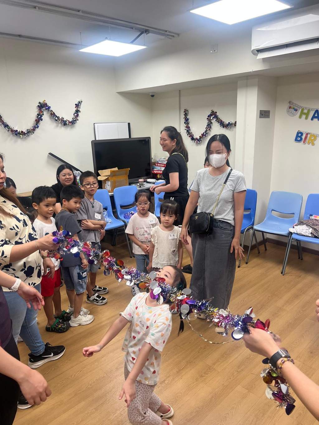 Children take turns moving through a decorated hoop.