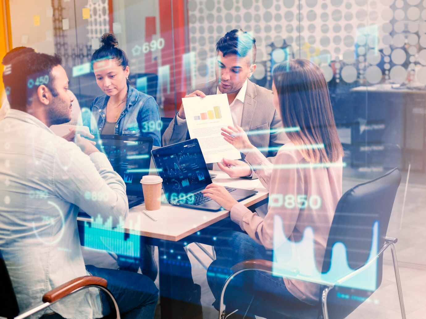 A group of people working collaboratively in a modern office setting. The image conveys a sense of teamwork and productivity in a tech-oriented workplace. 