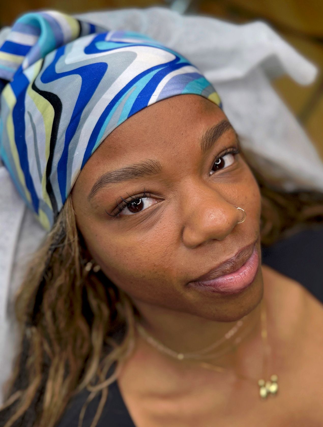 Close-up of a nano brow with ultra-fine, hair-like strokes creating a natural, full eyebrow next to a brown eye with long lashes.