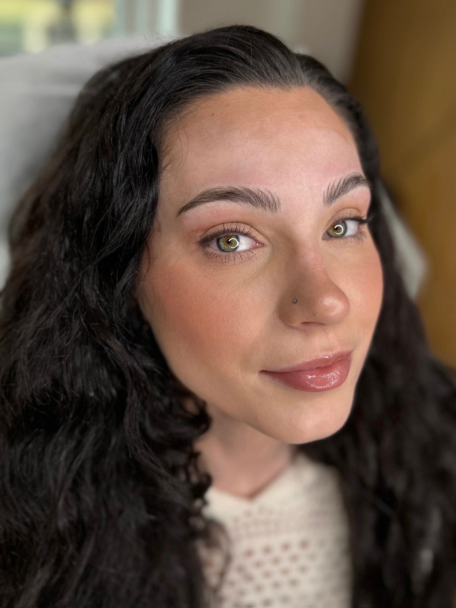 Close-up of manual microblading natural hair strokes, full face portrait photo of woman with green eyes done at MOKO Beauty.
