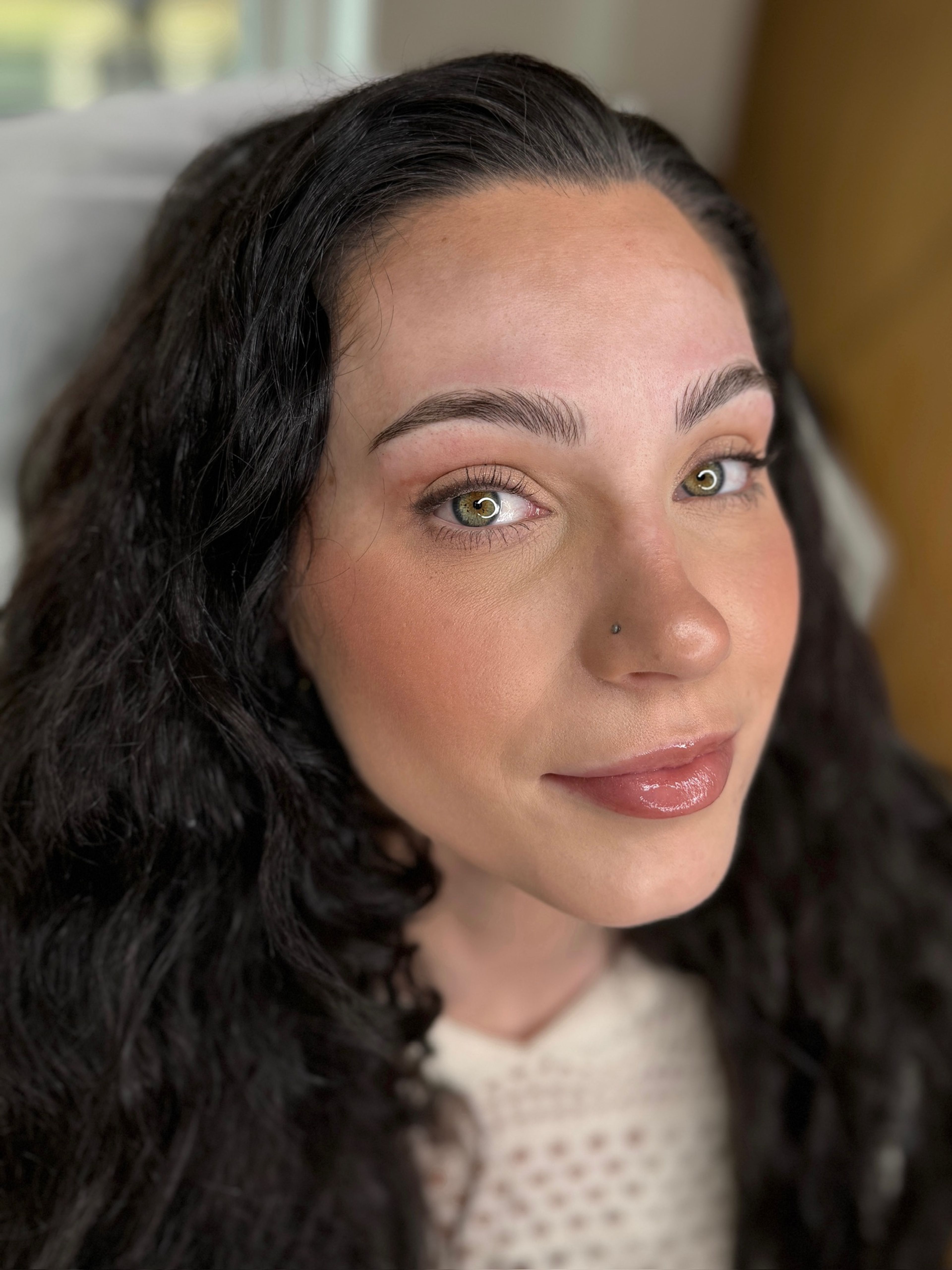 Close-up of manual microblading natural hair strokes, full face portrait photo of woman with green eyes done at MOKO Beauty.