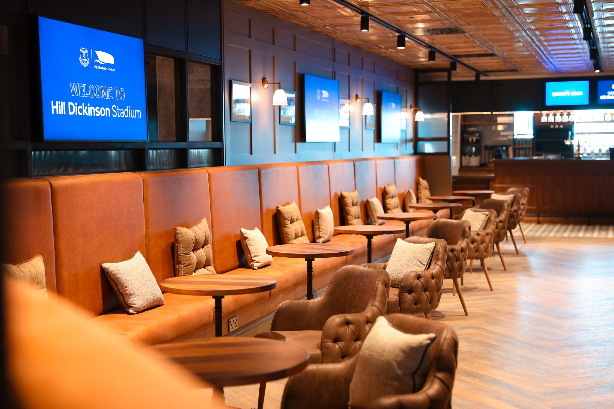 Village Street, Hill Dickinson Stadium: The Queen's Head lounge interior, tan leather banquettes and armchairs