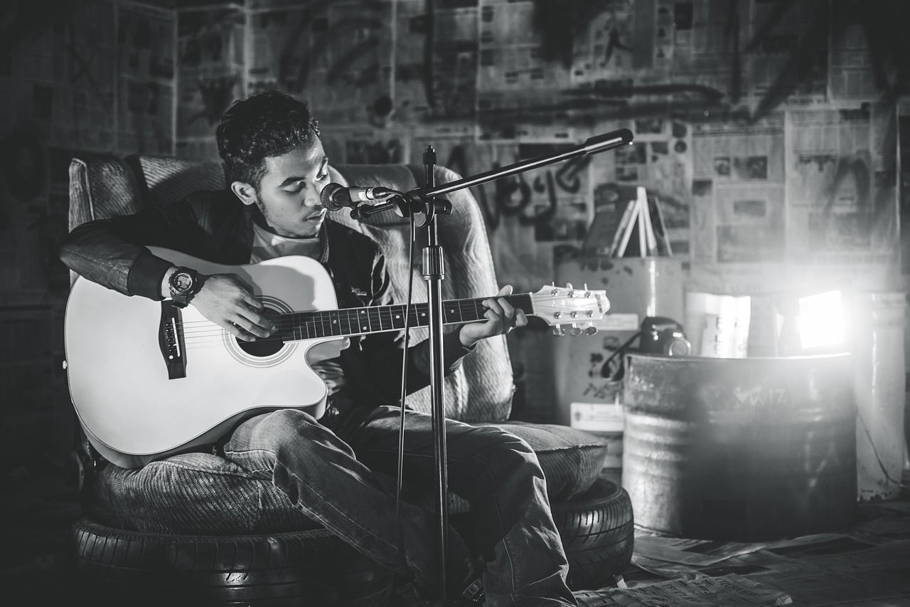 Acoustic guitarist performing in black and white, evoking Clapton's stripped-back 1970s style