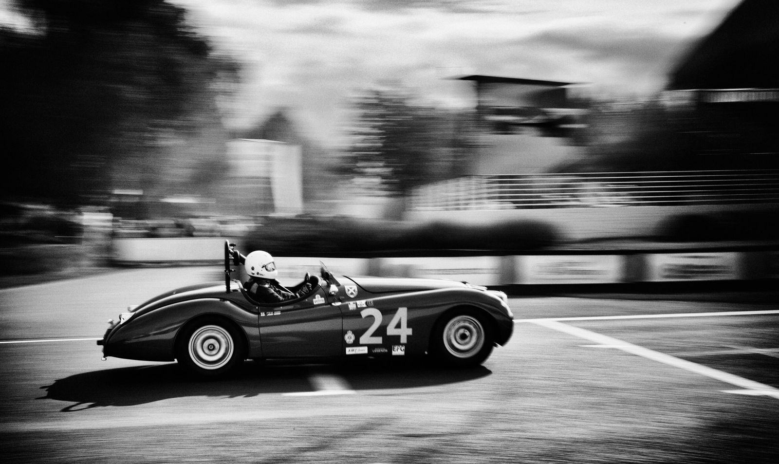 A classic Jaguar sports car racing on the Goodwood Motor Circuit