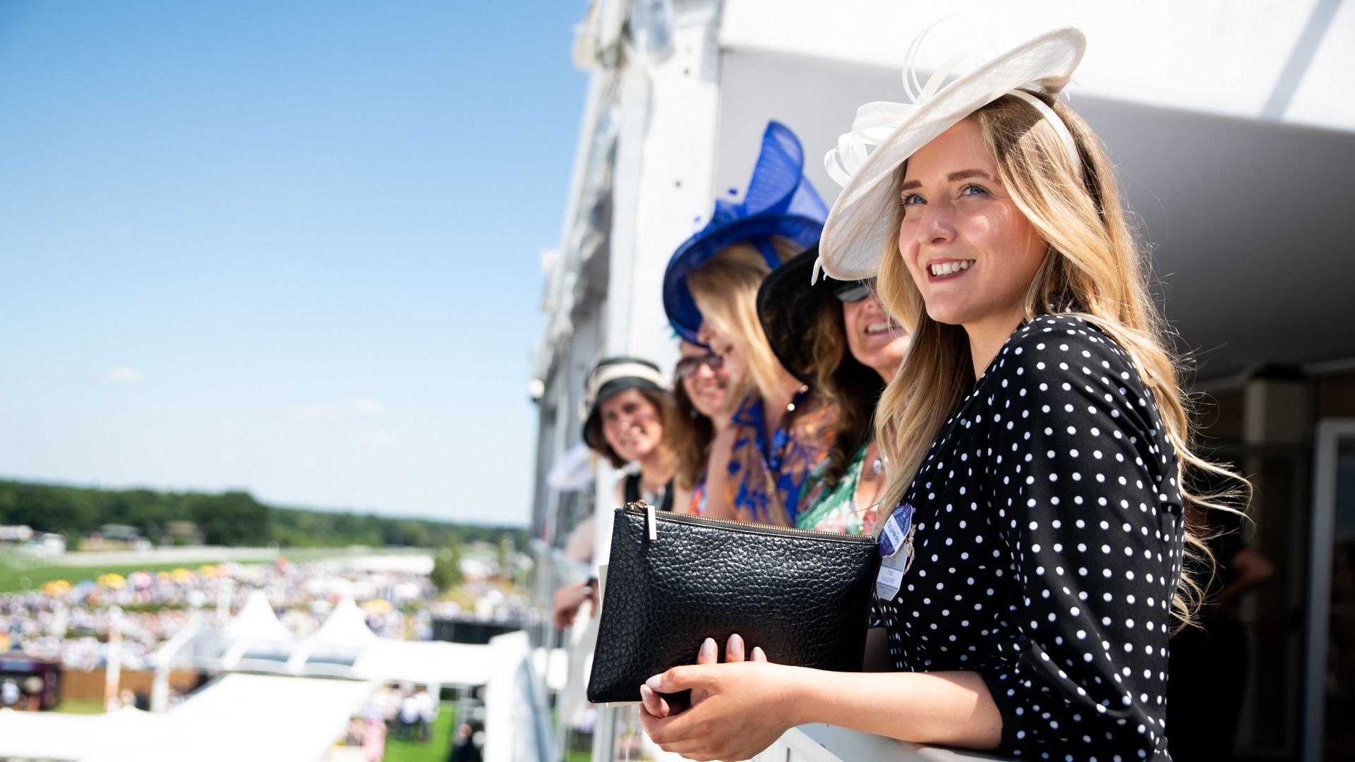 A hospitality space at Royal Ascot with guests in morning dress