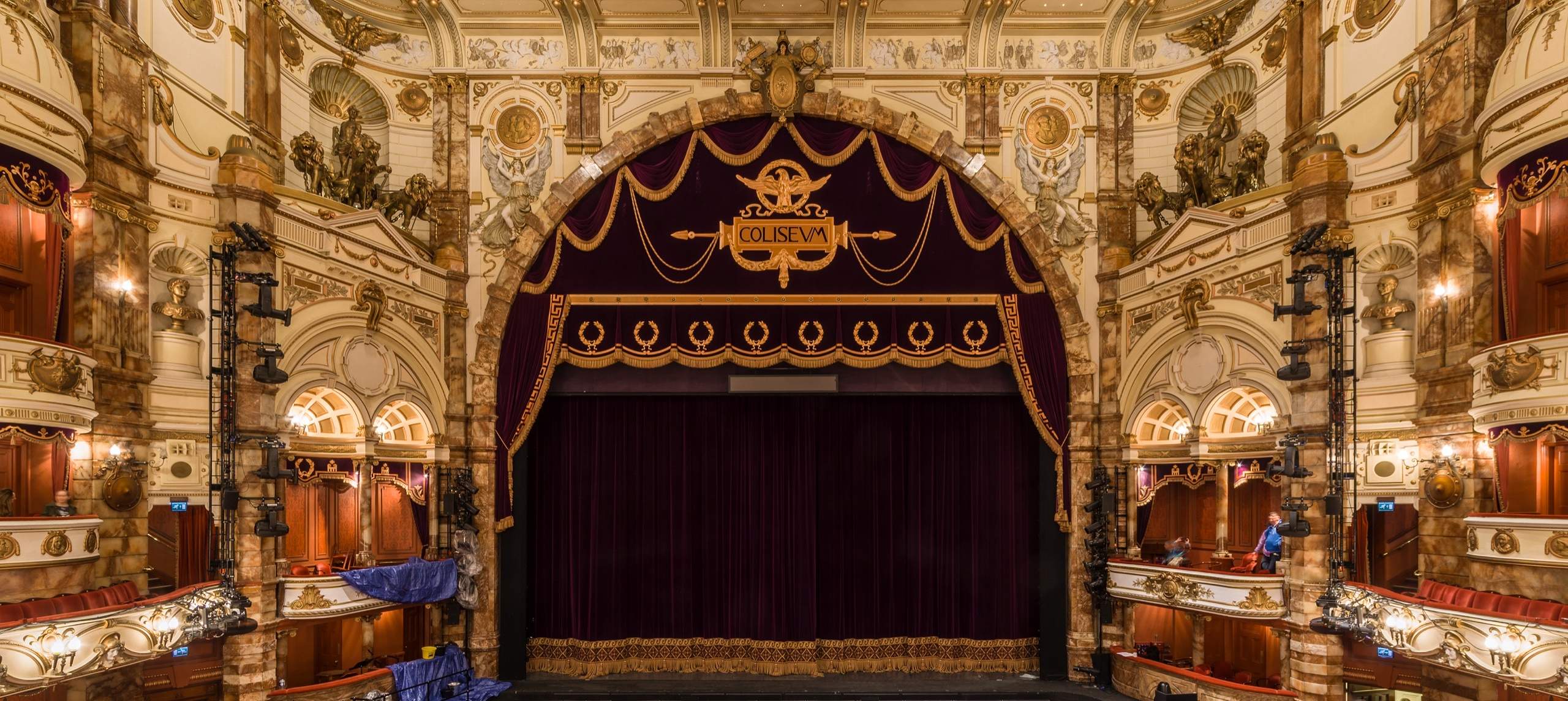The London Coliseum auditorium from the stalls: house curtain, boxes and gilded tiers