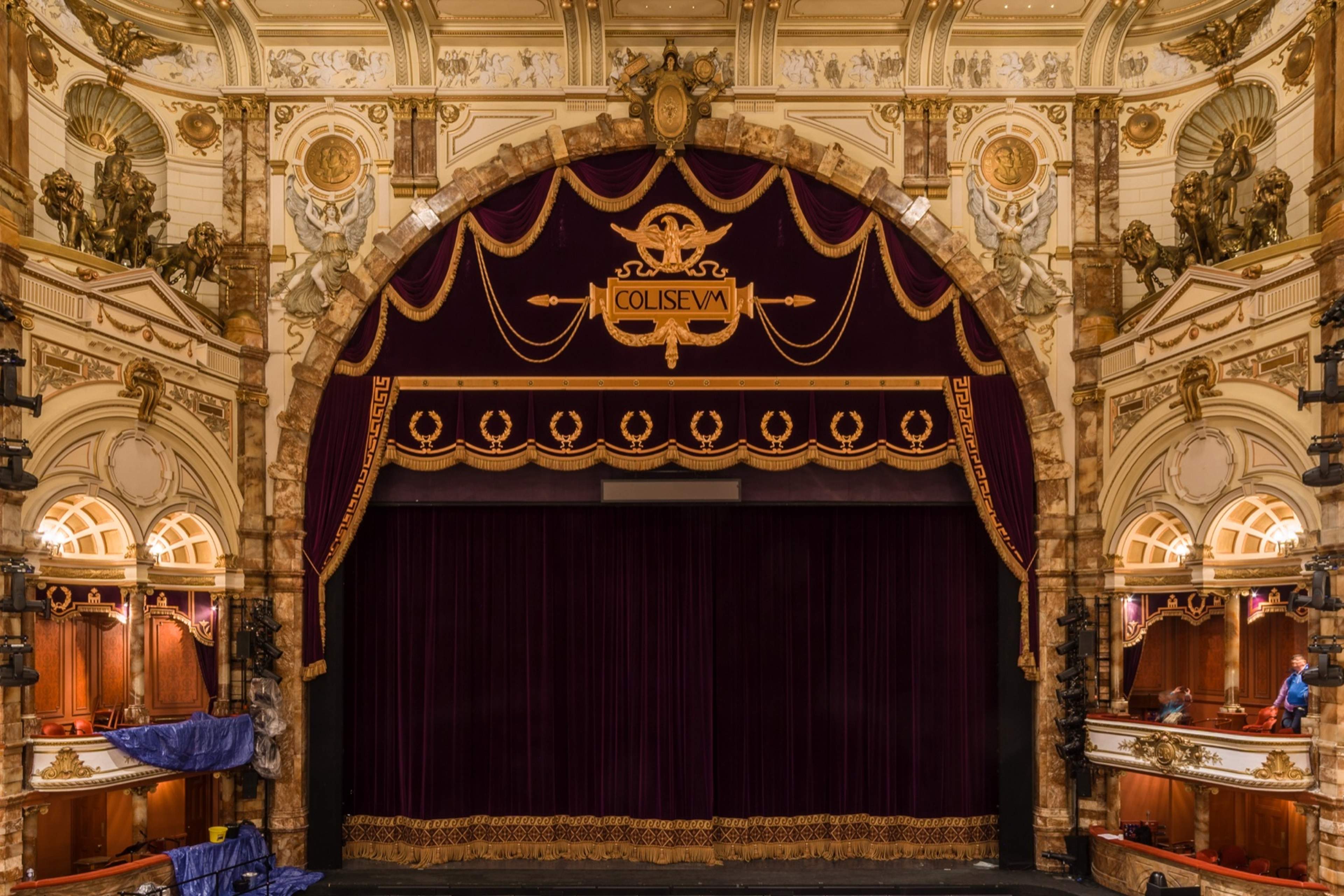 The London Coliseum auditorium from the stalls: house curtain, boxes and gilded tiers