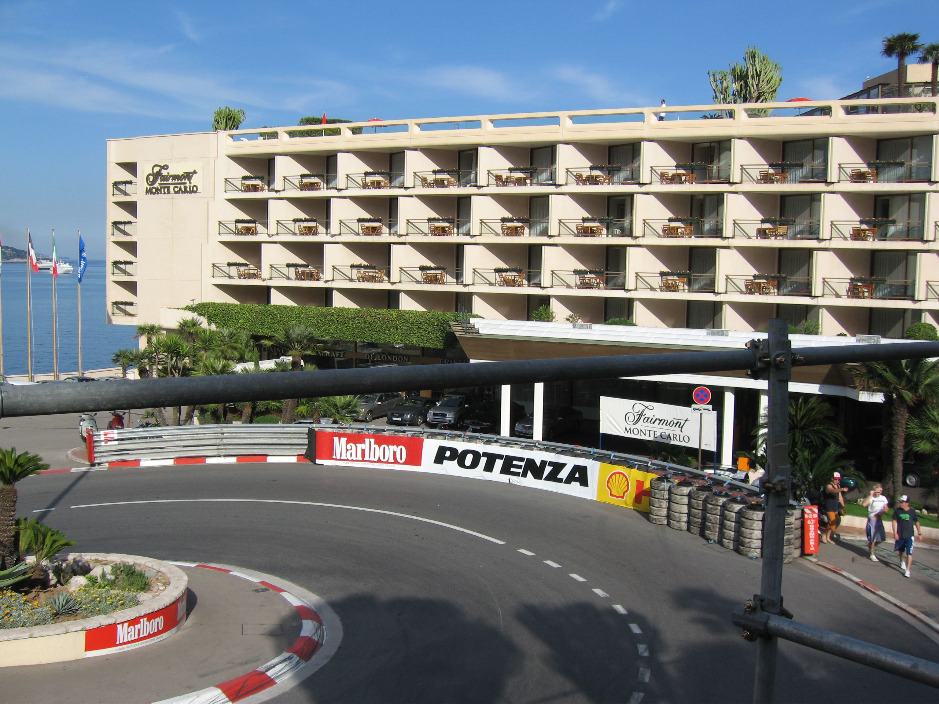 The Fairmont Monte-Carlo hotel above the tight hairpin corner, with red and white kerbs and trackside barriers