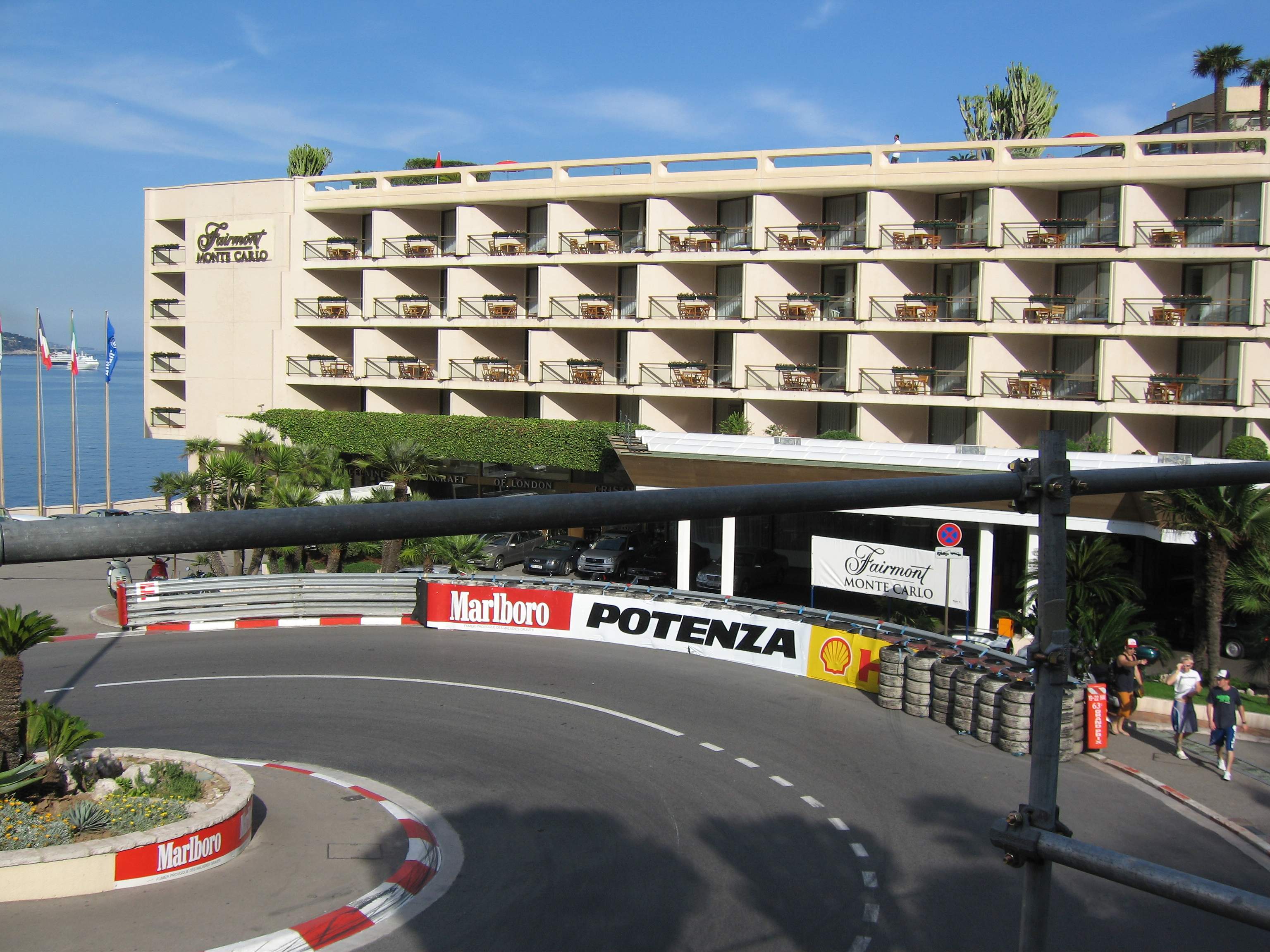 The Fairmont Monte-Carlo hotel above the tight hairpin corner, with red and white kerbs and trackside barriers