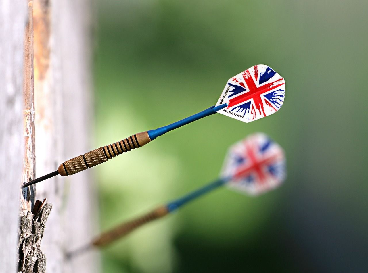 Darts being thrown at a dartboard during competition