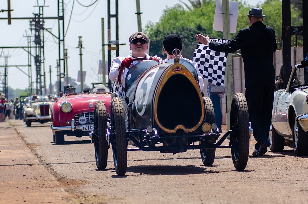 Vintage racing driver with chequered flag, evoking the early days of Formula 1