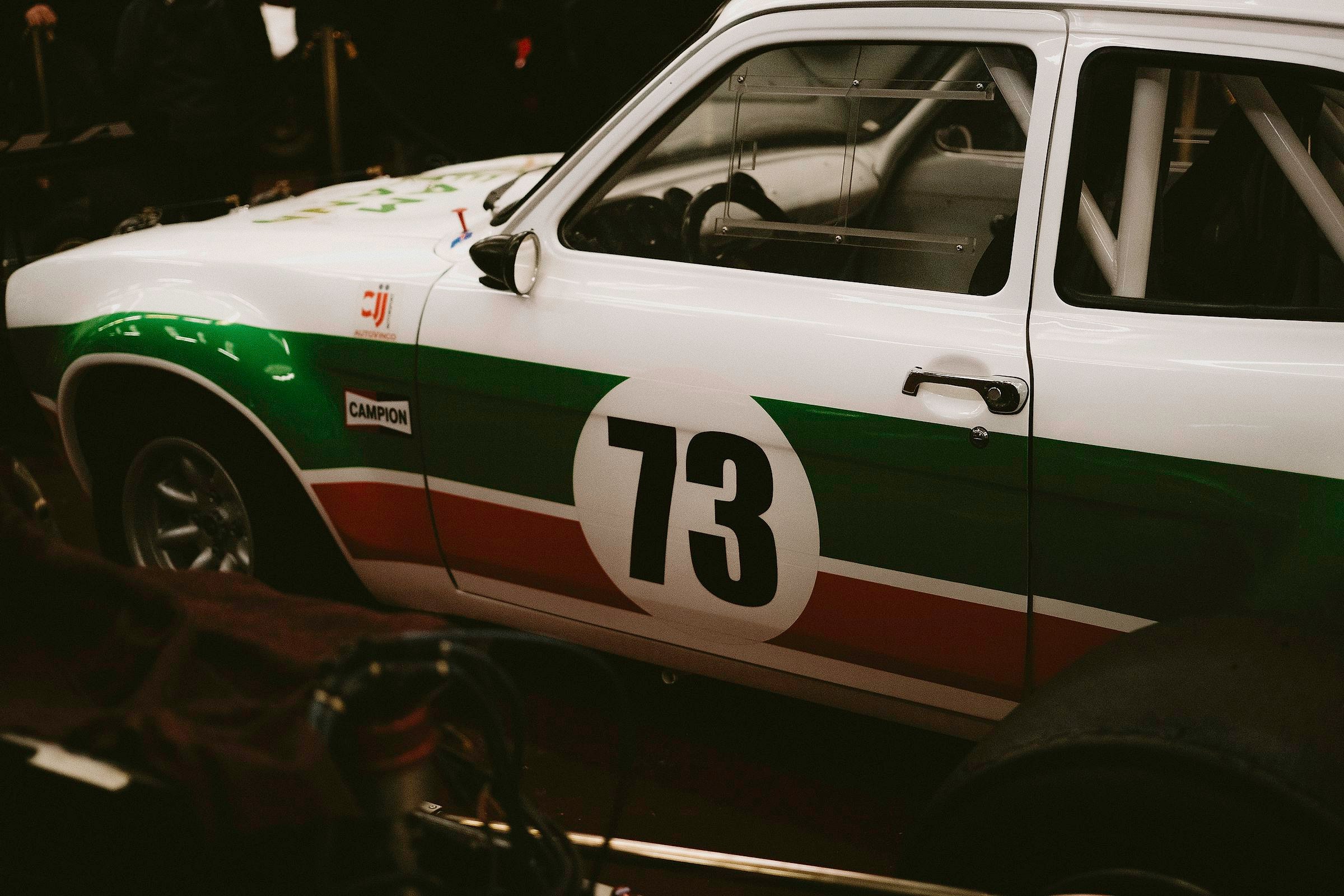 Goodwood Revival cars and crowd (White race car with green and red stripes, number 73)