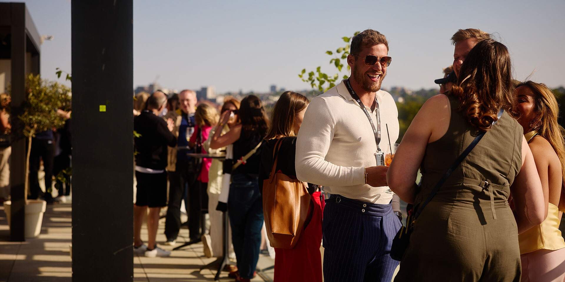 Guests socialising on The Sky Deck rooftop terrace with the London skyline behind