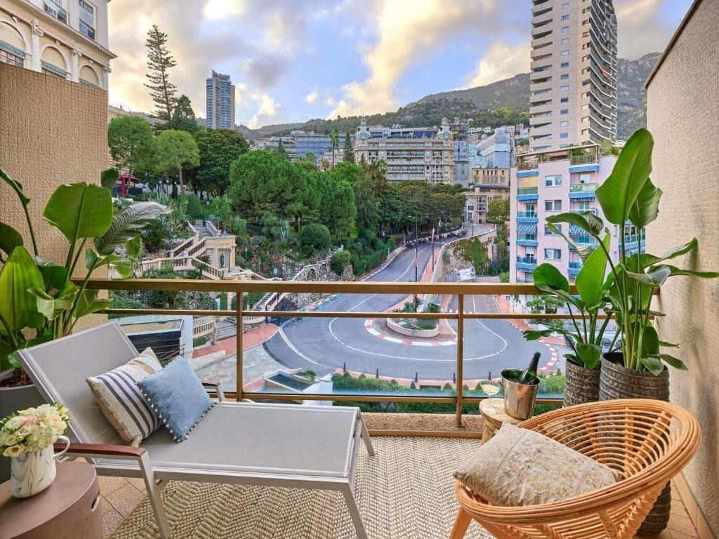 The hairpin bend of the Monaco Grand Prix circuit seen from a balcony at the Fairmont Monte-Carlo, with the hillside behind