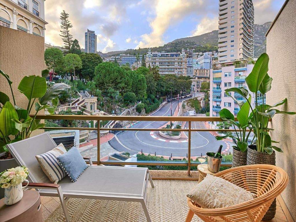 The hairpin bend of the Monaco Grand Prix circuit seen from a balcony at the Fairmont Monte-Carlo, with the hillside behind