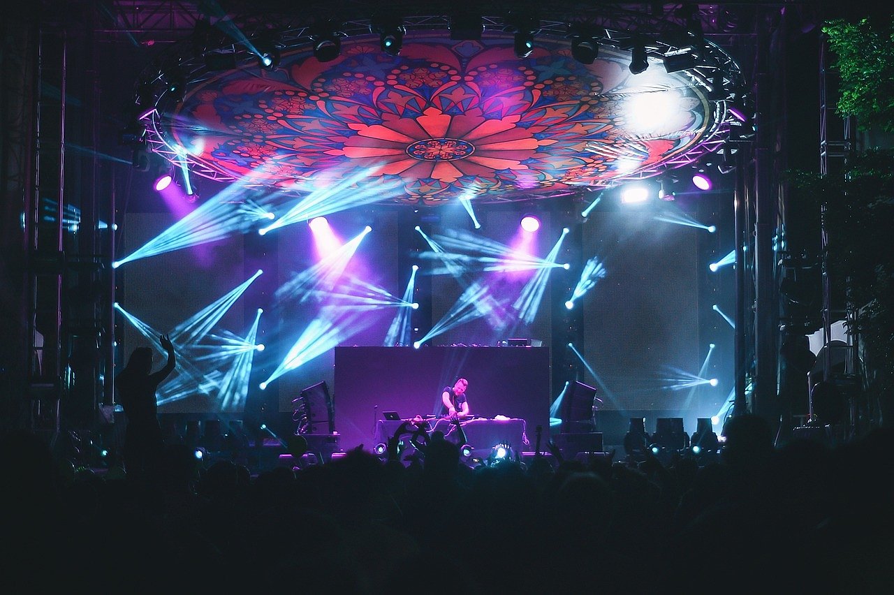 Concert crowd bathed in blue spotlight during a major live performance