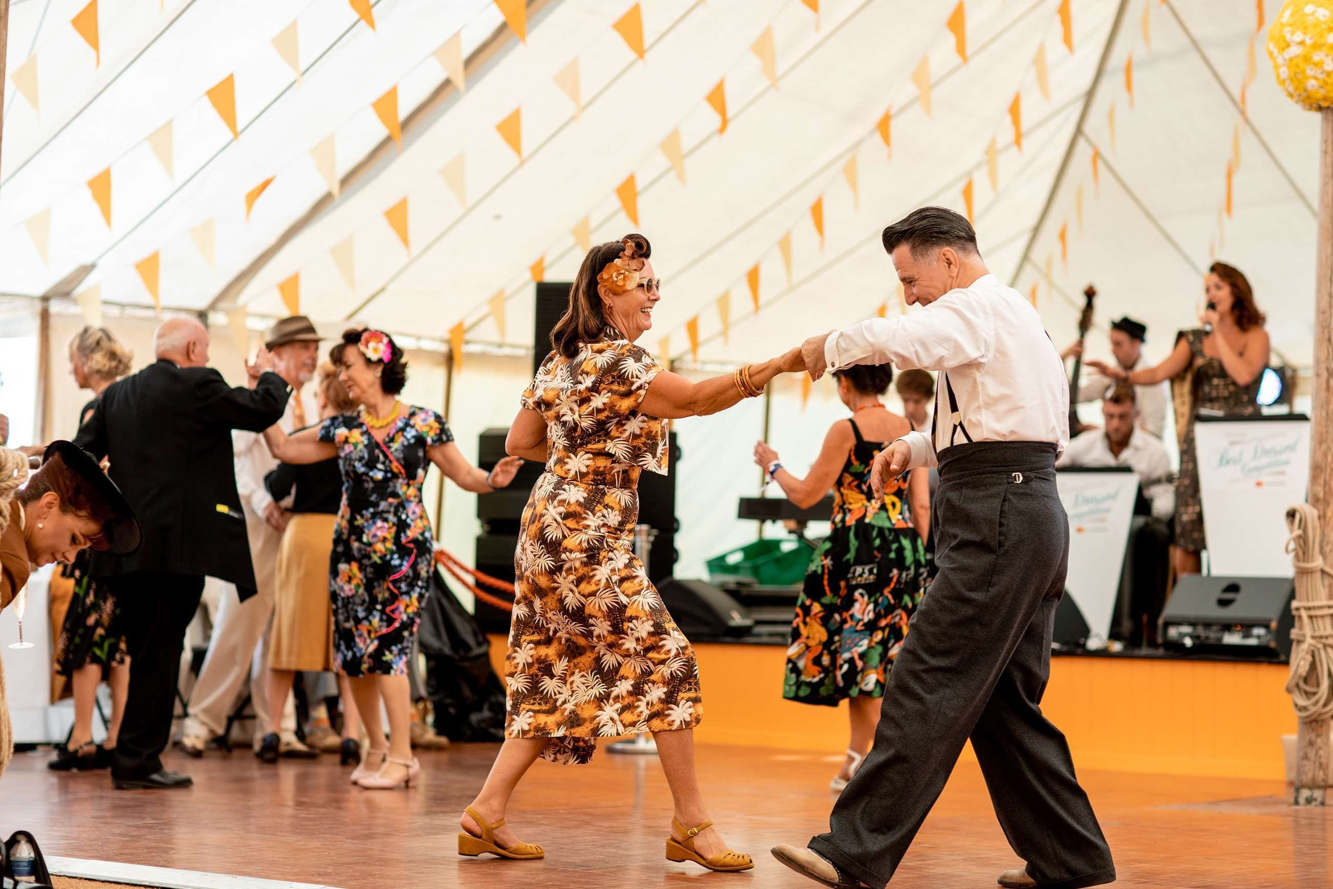 Spectators in period costume dancing at the Goodwood Revival