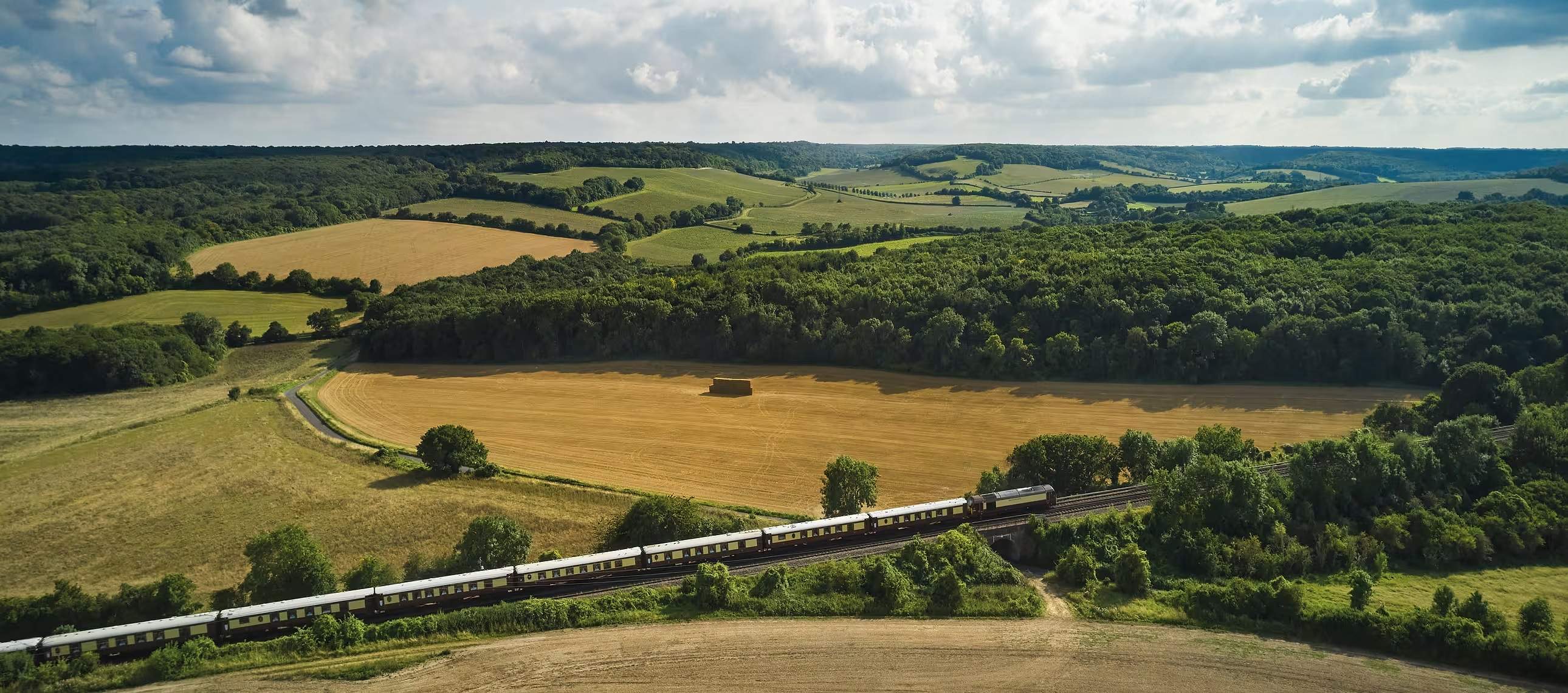 The umber-and-cream Belmond British Pullman winding through the English countryside