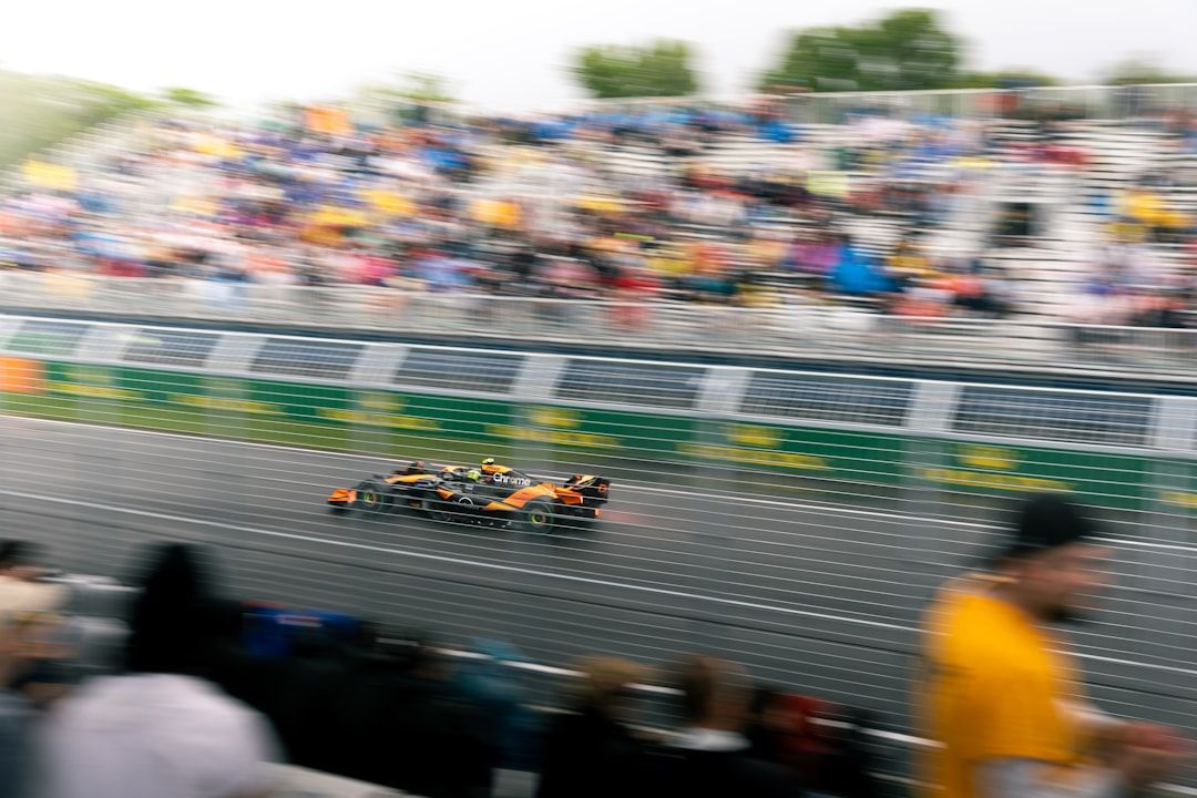 Formula 1 cars racing on track with spectators watching from grandstands