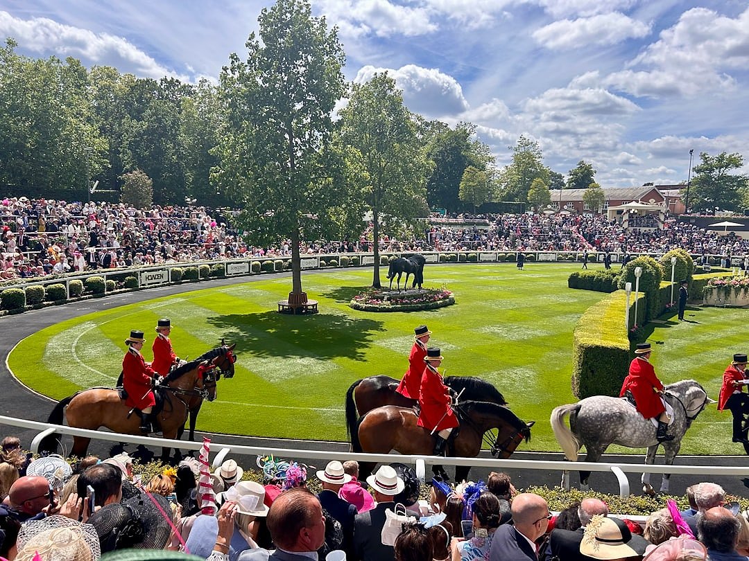 Horses racing at Royal Ascot in front of the grandstand