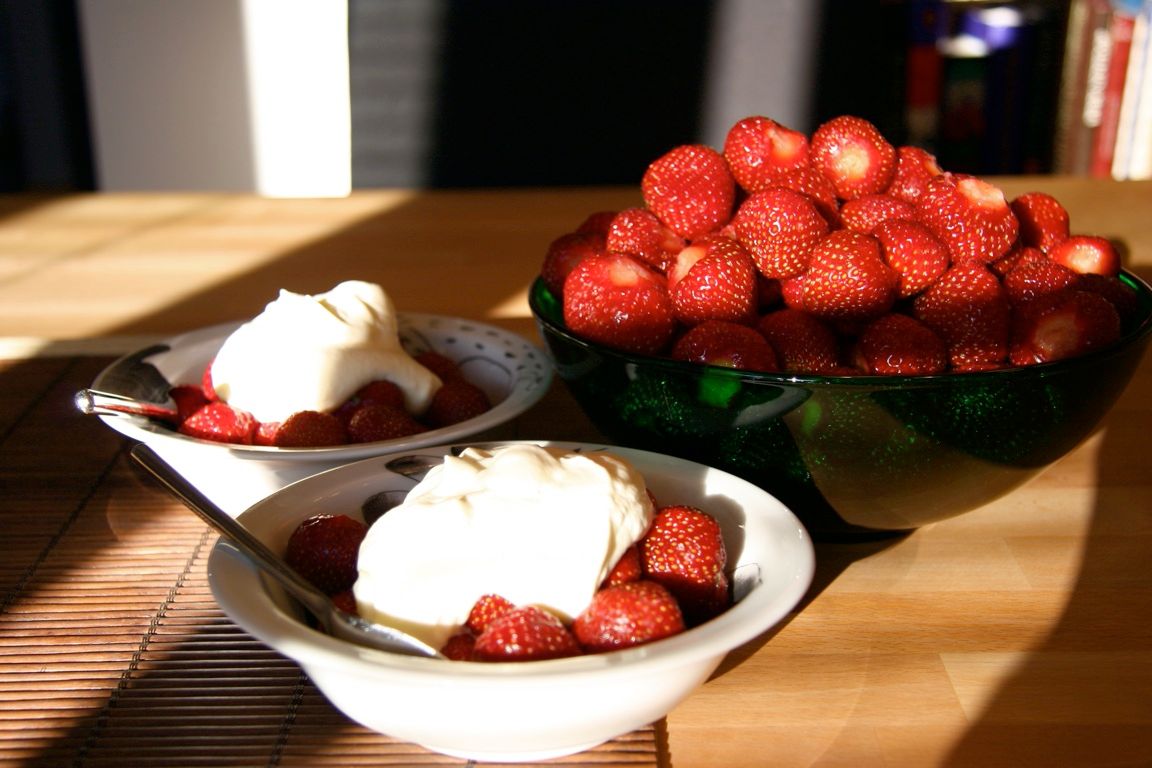 Bowls of fresh strawberries topped with cream