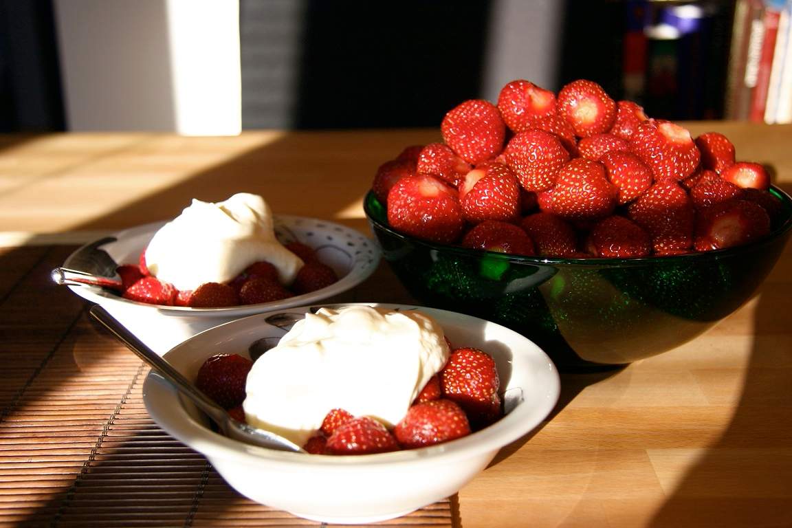Bowls of fresh strawberries topped with cream